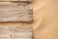 Old wooden walkway sprinkled with fine sand and overgrown with grass on the beach. Royalty Free Stock Photo