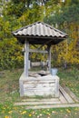 Old wooden water well with metal bucket in autumn forest Royalty Free Stock Photo