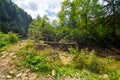 The old wooden weak bridge over small river in mountain forest Royalty Free Stock Photo