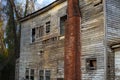 Old wooden weathered dilapidated abandoned two story house side view chimney Royalty Free Stock Photo