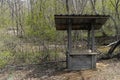 An old wooden well in the spring forest on the bank of a stream Royalty Free Stock Photo