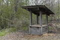 An old wooden well in the spring forest on the bank of a stream Royalty Free Stock Photo