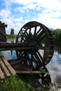 Old wooden wheel on the abandoned watermill on the river landscape
