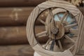 An old wooden wheel on the background of an old log house Royalty Free Stock Photo