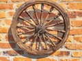 Old wooden wheel on a brick wall Royalty Free Stock Photo