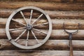 Old wooden wheel, retro oven fork on wooden wall Royalty Free Stock Photo