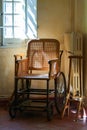 Old wooden wheelchair in the interior. Royalty Free Stock Photo