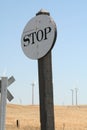 Old wooden white colored stop sign near wind farm