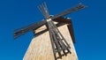 Old wooden windmill against blue sky. Windmill sails. Countryside background Royalty Free Stock Photo