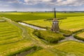 Old wooden windmill in green agricultural grassland