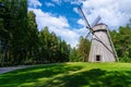 Old wooden windmill over meadow and cloudy sky, Royalty Free Stock Photo