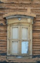 Old wooden window with closed shutters on the wall with scuffed paint. ancient, wooden architecture. Royalty Free Stock Photo