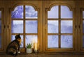 Old wooden window, domestic cat sitting, candle burns on windowsill, houseplant succulent, winter landscape behind frosty glass, Royalty Free Stock Photo