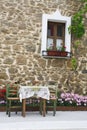 Old wooden window with flowers on stone wall Royalty Free Stock Photo