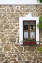 Old wooden window with flowers on stone wall Royalty Free Stock Photo