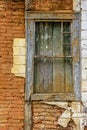 Old wooden window ruined by time on the facade of abandoned house