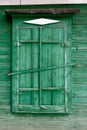 Old wooden window in a wall painte in green color