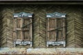 Old wooden windows with closed shutters on weathered wall Royalty Free Stock Photo