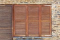 Old wooden windows frame on stone wall in Spain.