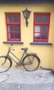 Old wooden windows with lamps and a red bicycle is a common sight in Ireland Royalty Free Stock Photo