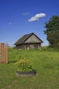 Old woodshed on green grass meadow