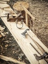 Old woodworking hand tool: wooden plane, chisel ax, and drawing knife in a carpentry workshop on wooden bench ground Royalty Free Stock Photo