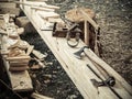 Old woodworking hand tool: wooden plane, chisel ax, and drawing knife in a carpentry workshop on wooden bench ground