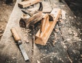 Old woodworking hand tool: wooden plane, chisel and drawing knife in a carpentry workshop on dirty rustic table covered