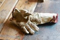 Old working gloves over wooden table, on a metal woodworking machine construction tools Royalty Free Stock Photo