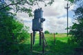 Old working rural electrical distribution transformer in the forest. Sunny day, the concept of industrial. Royalty Free Stock Photo