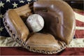 worn baseball in vintage catcher\'s mitt on American flag Royalty Free Stock Photo