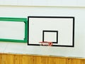 Old Worn Basketball Hoop And White Shool Gym Wall