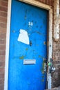 Old worn blue door with broken lock and old torn notice on door
