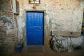 Old and worn blue wooden door with ironwork. Rustic blue door entrance to an old stone house Royalty Free Stock Photo