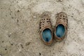 Old worn brown shoes, standing alone on the sandy beach. Trampled men`s shoes in nature without Royalty Free Stock Photo