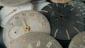 Old worn clock dials. Aged scratched round watch faces with hands and numbers. Pile of metal broken and disassembled Royalty Free Stock Photo
