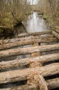 An old, worn, dangerous wooden bridge over a small river