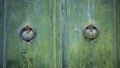 Old and worn double-leaf door with metal knockers or knockers and painted Royalty Free Stock Photo