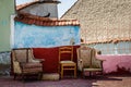 Old Worn Furniture Left in Front of an Old House wall