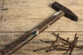 Old worn hammer and rusty nails on wooden background. Copy space Royalty Free Stock Photo