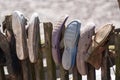 Old worn house slippers on wooden fence. the concept of poverty