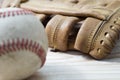 Old worn leather baseball glove and used ball on a wooden table Royalty Free Stock Photo