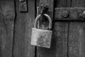 old weathered lock on a collapsing wooden door