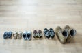 Old worn military boots, women`s shoes and lot of baby shoes on wooden floor top view