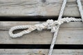 Old worn mooring rope of a yacht on a wooden jetty sea background.