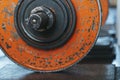 Old worn orange painted weight plates loaded onto a barbell