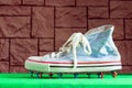 An old worn-out football sneaker with multicolored roofing screws instead of spikes stands forgotten on a closed football ground Royalty Free Stock Photo