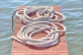 Old worn-out mooring rope rolled into a bay lies on a wood Royalty Free Stock Photo