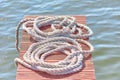 Old worn-out mooring rope rolled into a bay lies on a wood Royalty Free Stock Photo