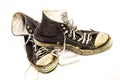 Old worn out pair of old black and white high top tennis shoes on white background Royalty Free Stock Photo